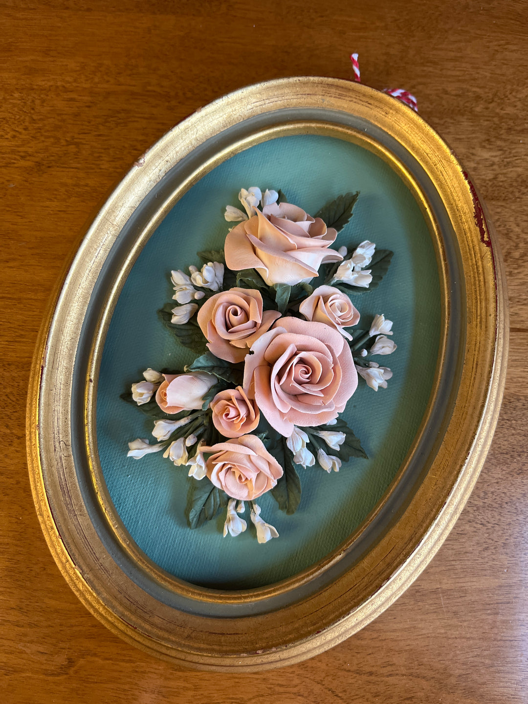 gold oval frame with clay flowers